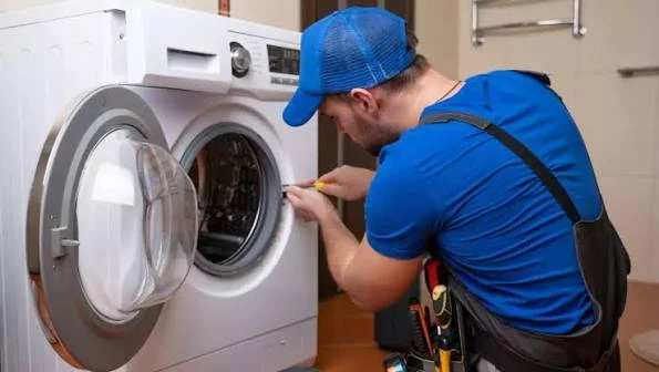Technician checking the door opening and seal of a front-loading washing machine